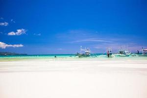 perfect tropisch strand met turkoois water en zeilboten foto