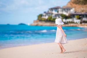 klein meisje in hoed op het strand tijdens Caribische vakantie foto