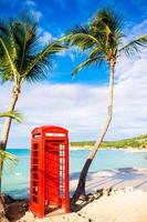 mooi landschap met een klassiek telefoon stand Aan de wit zanderig strand in antigua foto