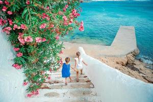 familie vakantie in Europa. vader en kinderen Bij straat van typisch Grieks traditioneel dorp Aan Mykonos eiland, in Griekenland foto