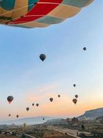 heet lucht ballon vliegend over- rotsachtig landschappen in cappadocia met mooi lucht Aan achtergrond foto