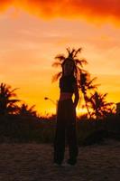schattig tiener mooi meisje Aan tropisch kust Bij zonsondergang foto