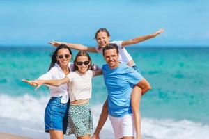 familie van vier hebben pret samen Aan strand vakantie in Florida foto