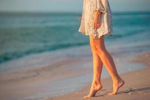 vrouw poten Aan de strand detailopname. vrouw in jurk wandelen Aan de strand foto