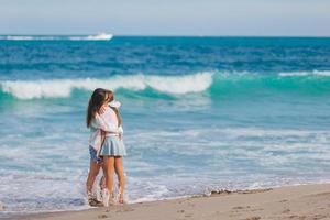 aanbiddelijk weinig meisje en jong moeder Aan tropisch wit strand foto