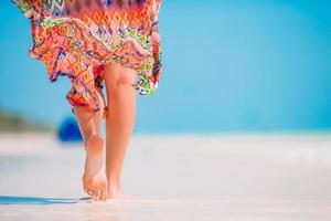 vrouw voeten Aan de wit zand strand in Ondiep water foto