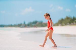 schattig weinig meisje Bij strand gedurende caraïben vakantie foto