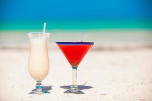 twee cocktails, pina colada en aardbei margarita Aan wit zand strand foto