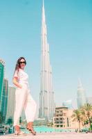 gelukkig vrouw wandelen in Dubai met wolkenkrabber in de achtergrond. foto