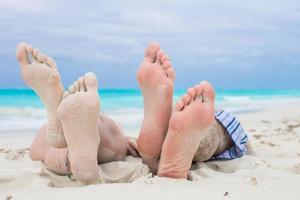 dichtbij omhoog mannetje en vrouw voeten Aan wit zand foto