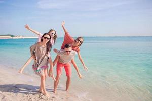 gelukkig mooi familie Aan een tropisch strand vakantie foto