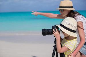 weinig meisje met camera en jong moeder het schieten landschap foto