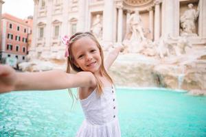 aanbiddelijk weinig meisje achtergrond Trevi fontein, Rome, Italië. foto