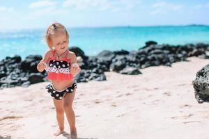 schattig klein meisje veel plezier op tropisch strand tijdens vakantie foto