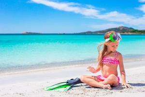 weinig meisje met flippers en stofbril voor snorkelen Aan de strand foto