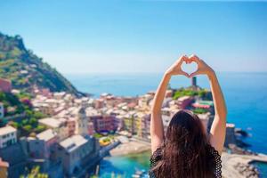 gelukkig meisje maken met handen hart vorm Aan de oud kust- stad- achtergrond van vernazza, cinque terre nationaal park. Europese vakantie. foto