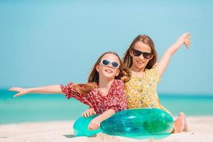 weinig gelukkig grappig meisjes hebben een veel van pret Bij tropisch strand spelen samen. foto