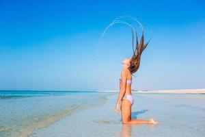 schattig actief meisje op het strand tijdens de zomervakantie foto