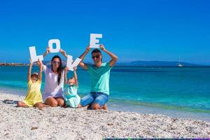 jong gelukkig familie met twee kinderen Aan tropisch vakantie foto