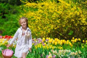 voorjaar tuin, voorjaar bloemen, schattig weinig meisje en tulpen foto