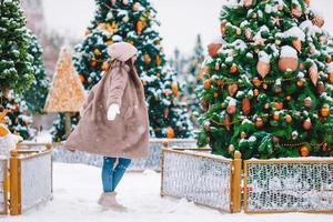 gelukkig meisje in de buurt dennenboom Afdeling in sneeuw voor nieuw jaar. foto