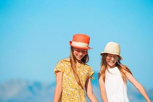 aanbiddelijk weinig kinderen Aan de strand gedurende zomer vakantie foto