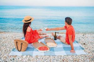 familie hebben een picknick Aan de strand foto