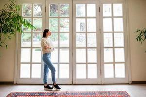 mooi meisje Aan de terras looks in een groot venster in een knus winkel hotel foto