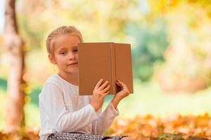 portret van aanbiddelijk weinig meisje buitenshuis Bij mooi herfst foto