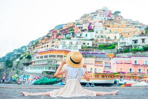 aanbiddelijk weinig meisje Aan warm en zonnig zomer dag in positano stad- in Italië foto