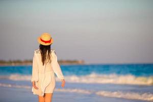 vrouw houdende Aan de strand genieten van zomer vakantie op zoek Bij de zee foto