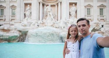 vader en kinderen in de buurt fontana di trevi, Rome, Italië. foto