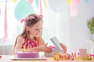 Kaukasisch meisje Bij verjaardag. feestelijk kleurrijk achtergrond met ballonnen. verjaardag partij en wensen concept. foto