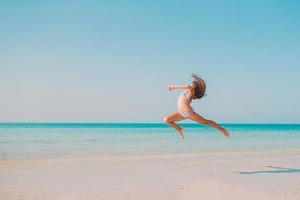 schattig actief meisje op het strand tijdens de zomervakantie foto