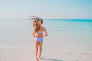 schattig actief meisje op het strand tijdens de zomervakantie foto