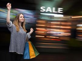 jong vrouw met papier boodschappen doen Tassen gedurende een uitverkoop foto