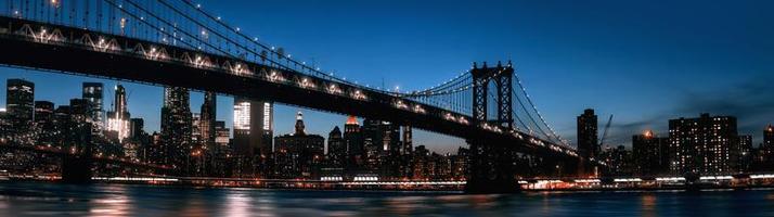 Manhattan horizon en Manhattan brug Bij nacht foto