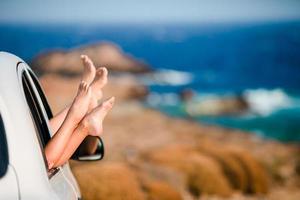 zomer vakantie, vakantie, reis, weg reis en mensen concept - dichtbij omhoog van weinig meisje voeten tonen van auto venster foto