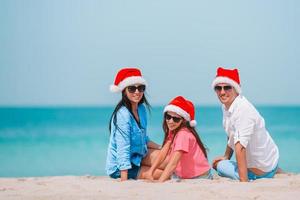 gelukkig familie met twee kinderen in de kerstman hoed Aan zomer vakantie foto