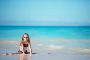 aanbiddelijk weinig meisje Bij strand hebben een veel van pret in Ondiep water foto