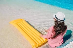 mooie jonge vrouw ontspannen in het zwembad. gelukkig meisje in buitenzwembad bij luxehotel foto