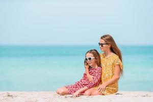 weinig gelukkig grappig meisjes hebben een veel van pret Bij tropisch strand spelen samen. foto