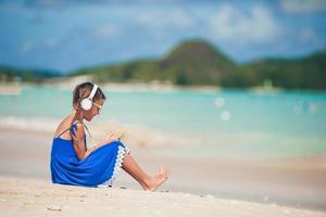 klein schattig meisje luisteren muziek achtergrond zee foto