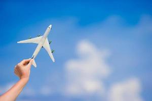 klein wit miniatuur van een vliegtuig Aan achtergrond van blauw lucht foto