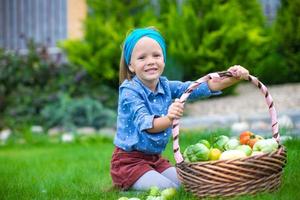 weinig meisje met manden vol van tomaten foto