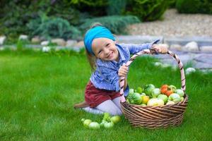 weinig meisje met manden vol van tomaten foto