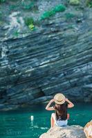 jong meisje in een inham Aan een rots in de cinque terre reserveren. verbijsterend natuur en vers lucht foto