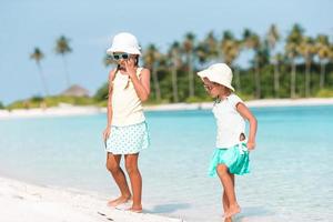 schattige kleine meisjes die plezier hebben tijdens strandvakantie foto