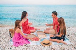 familie hebben een picknick Aan de strand foto