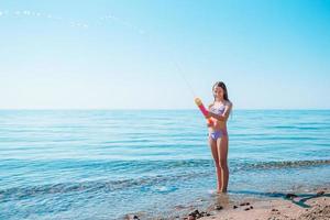 schattig actief meisje op het strand tijdens de zomervakantie foto